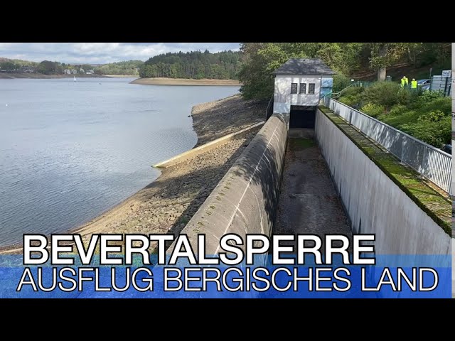 Die Bevertalsperre mit Wasser, Ufer und einem kleinen Gebäude am Damm.